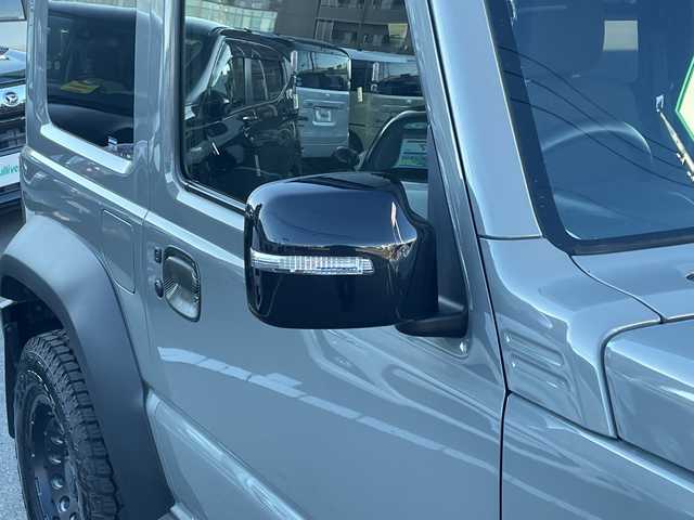 スズキ ジムニー シエラ JC 長野県 2023(令5)年 2.7万km ミディアムグレー 禁煙車/ワンオーナー/純正SDナビ/フルセグTV/バックカメラ/（Bluetooth/CD/DVD/HDMI）/社外１５インチアルミ（ＮＩＴＲＯ　ＰＯＷＥＲ）/前席シートヒーター/背面スペアタイヤ/クルーズコントロール/アイドリングストップ/衝突被害軽減システム/横滑り防止装置/レーンキープアシスト/ダウンヒルアシストコントロール/LEDヘッドライト/ウインカーミラー/社外フロアマット/カーテンエアバッグ/高低速2段切替レバー /ステアリングスイッチ/プッシュスタート/スマートキー