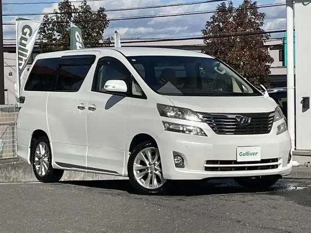 トヨタ ヴェルファイア 2．4V 宮城県 2009(平21)年 18万km ホワイトパールクリスタルシャイン 純正ナビ/AM/FM/BT/CD/DVD/AUX/ワンセグTV/バックカメラ/社外フリップダウンモニター/前席パワーシート/オットマン/両側パワースライドドア/ステアリングスイッチ/MTモード搭載/コーナーセンサー/クルーズコントロール/横滑り防止装置/衝突被害軽減システム/純正フロアマット/ウィンカードアミラー/プッシュスタート/保証書・記録簿・取扱説明書