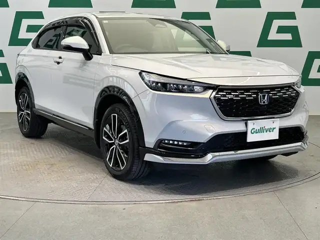 ホンダ ヴェゼル ハイブリッド e:HEV Z 鹿児島県 2023(令5)年 1.8万km プレミアムサンライトホワイトパール Hondaコネクトナビ/(フルセグ/Bluetooth/DVD/CD)/前後ドライブレコーダー/ビルトインETC/ハンズフリーアクセステールゲート/前席シートヒーター/ステアリングヒーター/HondaSENSING/　・衝突軽減ブレーキ（CMBS）/　・誤発進抑制機能/　・後方誤発進抑制機能/　・近距離衝突軽減ブレーキ/　・歩行者事故低減ステアリング/　・路外逸脱抑制機能/　・渋滞追従機能付アダプティブクルーズコントロール（ACC）/　・車線維持支援システム（LKAS）/　・トラフィックジャムアシスト（渋滞運転支援機能）/　・先行車発進お知らせ機能/　・標識認識機能/　・オートハイビーム/電動パーキングブレーキ/ブレーキホールド/純正アルミホイール/純正フロアマット/ドアバイザー