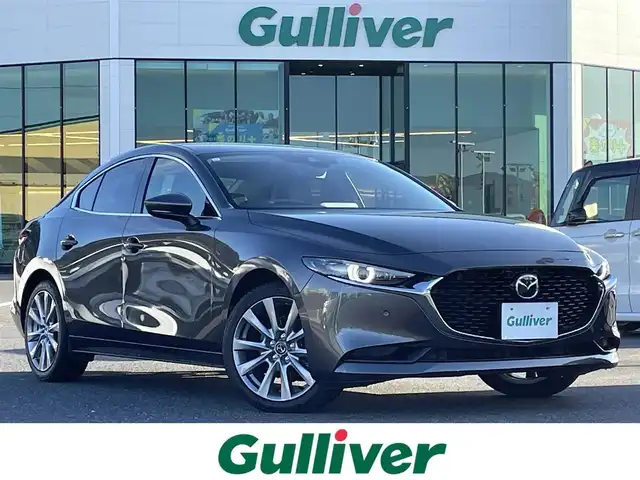 マツダ マツダ３セダン XD Lパッケージ 島根県 2021(令3)年 2.7万km マシーングレープレミアムM 登録時走行距離 26852km/BOSEサウンド/純正ナビ/(Bluetooth/AM/FM/フルセグテレビ/CD/DVD)/追従型クルーズコントロール/レーンキープアシスト/コーナーセンサー/ブラインドスポットモニター/ヘッドアップディスプレイ/全周囲カメラ/パワーシート/メモリーシート/シートヒーター/オートマチックハイビーム/オートライト/純正フロアマット/ETC/純正アルミ１８インチ
