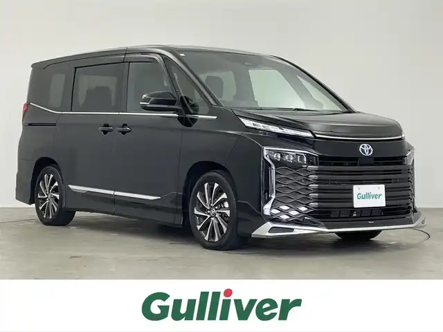 トヨタ ヴォクシー ハイブリッド S－Z 埼玉県 2024(令6)年 1.3万km アティチュードブラックマイカ モデリスタエアロ/10.5インチディスプレイオーディオ/　CD DVD　Bluetooth　AppleCarPlay　フルセグ/14インチフリップダウンモニター/ＡＬＰＩＮＥミラー型ドライブレコーダー/両側パワースライドドア/バックカメラ/レーダークルーズコントロール/ビルトインＥＴＣ２．０/ハーフレザーシート/シートヒーター/コーナーセンサー/オートブレーキホールド/プリクラッシュセーフティ/純正１７インチアルミホイール/社外テールランプ/LEDオートライト