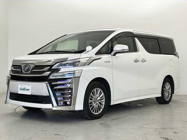 トヨタ ヴェルファイア ハイブリット Z 宮城県 2018(平30)年 6.9万km ホワイトパールクリスタルシャイン ワンオーナー/禁煙車/寒冷地仕様/ツインムーンルーフ/純正フリップダウンモニター/トヨタセーフティーセンス/・レーダークルーズコントロール/・プリクラッシュセーフティーシステム/・レーントレーシングアシスト/・オートマチックハイビーム/・ロードサインアシスト/・クリアランスソナー/純正9インチナビ/（BT.AM.FM.CD.DVD.SD）/バックカメラ/フルセグテレビ/両側パワースライドドア/電動パーキングブレーキ/オートホールド/革巻きステアリング/ステアリングスイッチ/プッシュスタート/スマートキー/3列シート/オットマン/シートカバー/純正ドアバイザー/純正17インチアルミホイール/純正エンジンスターター/LEDヘッドライト/LEDフォグランプ/リアフォグ/社外フロアマット　/nanoeエアコン/横滑り防止機能/アイドリングストップ