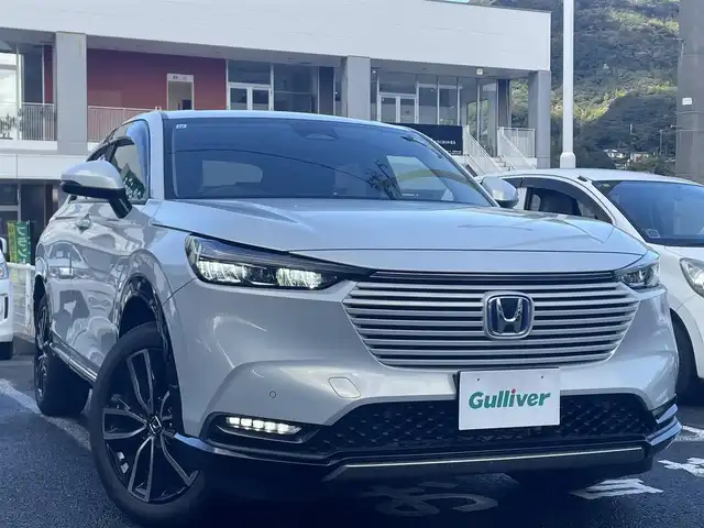 ホンダ ヴェゼル ハイブリッド e:HEV Z 長崎県 2021(令3)年 3.1万km プレミアムサンライトホワイトパール ワンオーナー車両/純正ディスプレイオーディオ（ナビ機能、フルセグ、AM、FM、BTオーディオ、AppleCarPlay、AndroidAuto）/バックカメラ/電動リアゲート/クルーズコントロール/パドルシフト/DNシートヒーター/ハーフレザー調シートカバー/ETC/BSM/電動パーキング/パーキングセンサー/電動格納ウインカーミラー