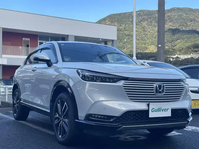 ホンダ ヴェゼル ハイブリッド e:HEV Z 長崎県 2021(令3)年 3.1万km プレミアムサンライトホワイトパール ワンオーナー車両/純正ディスプレイオーディオ（ナビ機能、フルセグ、AM、FM、BTオーディオ、AppleCarPlay、AndroidAuto）/バックカメラ/電動リアゲート/クルーズコントロール/パドルシフト/DNシートヒーター/ハーフレザー調シートカバー/ETC/BSM/電動パーキング/パーキングセンサー/電動格納ウインカーミラー