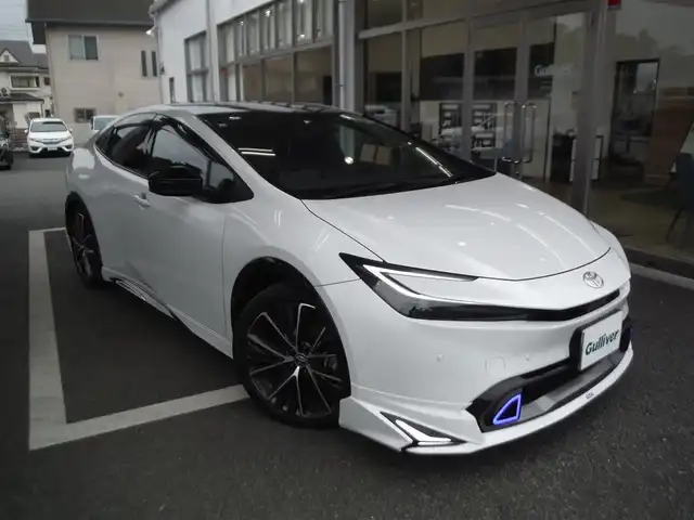 トヨタ プリウス Z 東京都 2024(令6)年 1.6万km パール ワンオーナー車 4WD/保証書・ユーザーガイドあり/モデリスタNEOエアロ/パノラマルーフ/純正12.3インチナビ・TV/　TVジャンパー・2.0ETC/　パノラミックビューモニター/　デジタルインナーミラー/　置くだけ充電/パワーバックドア/トヨタチームメイト/　セーフティセンス/　ブラインドスポットモニター/　クリアランスソナー/運転席パワーシート/　前席シートヒーター/　ベンチレーター/　ステアリングヒーター/フットイルミ/AC100V電源/スマートキー×2個