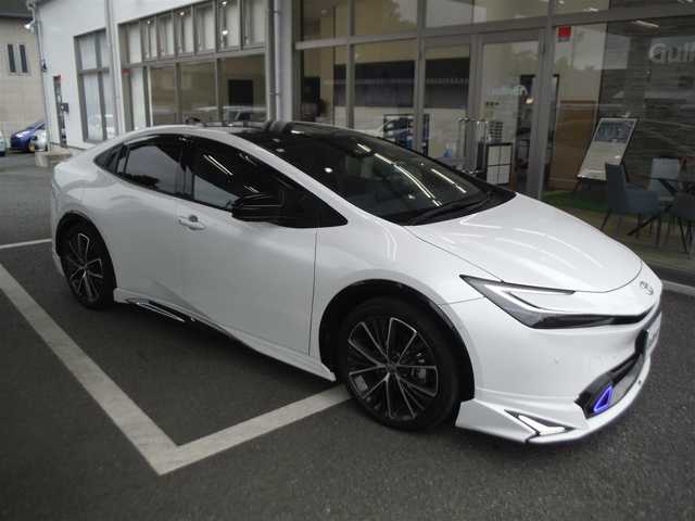 トヨタ プリウス Z 東京都 2024(令6)年 1.6万km パール ワンオーナー車 4WD/保証書・ユーザーガイドあり/モデリスタNEOエアロ/パノラマルーフ/純正12.3インチナビ・TV/　TVジャンパー・2.0ETC/　パノラミックビューモニター/　デジタルインナーミラー/　置くだけ充電/パワーバックドア/トヨタチームメイト/　セーフティセンス/　ブラインドスポットモニター/　クリアランスソナー/運転席パワーシート/　前席シートヒーター/　ベンチレーター/　ステアリングヒーター/フットイルミ/AC100V電源/スマートキー×2個