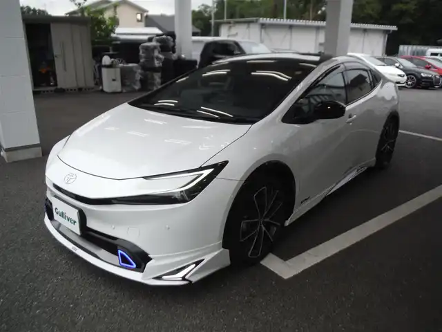 トヨタ プリウス Z 東京都 2024(令6)年 1.6万km パール ワンオーナー車 4WD/保証書・ユーザーガイドあり/モデリスタNEOエアロ/パノラマルーフ/純正12.3インチナビ・TV/　TVジャンパー・2.0ETC/　パノラミックビューモニター/　デジタルインナーミラー/　置くだけ充電/パワーバックドア/トヨタチームメイト/　セーフティセンス/　ブラインドスポットモニター/　クリアランスソナー/運転席パワーシート/　前席シートヒーター/　ベンチレーター/　ステアリングヒーター/フットイルミ/AC100V電源/スマートキー×2個