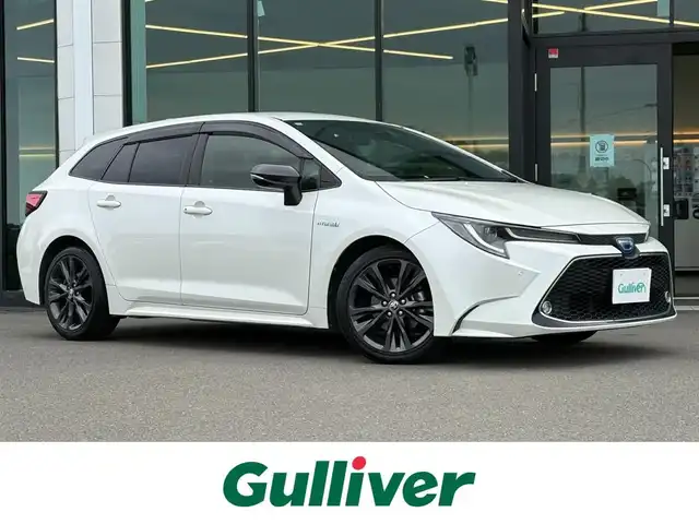 トヨタ カローラツーリング ハイブリッド ダブルバイビー 東京都 2019(令1)年 5.8万km ホワイトパールクリスタルシャイン TOYOTA純正ナビ付9インチディスプレイオーディオ/・フルセグTV/・Bluetooth接続/・T-Connect/・Apple Car Play/・Android Auto/Toyota Safety Sense/・レーントレーシングアシスト/・プリクラッシュセーフティ/・ブラインドスポットモニター/・リヤクロストラフィックアラート/・パーキングサポートブレーキ/・ロードサインアシスト/・レーダークルーズコントロール/・先行車発進告知/ヘッドアップディスプレイ/電子パーキング/オートホールド/プッシュスタート/ドライブレコーダー（DRT-H68A）/バックカメラ/ETC2.0/純正フロアマット/純正17インチアルミホイール/ハーフレザーシート/シートヒーター/ステアリングヒーター/LEDヘッドライト