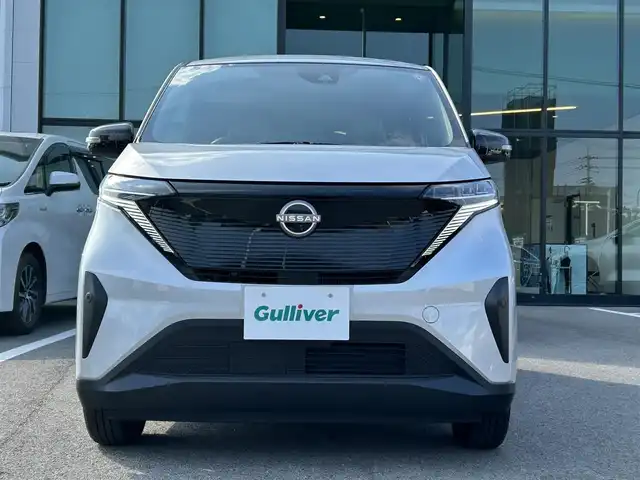 日産 サクラ X 愛媛県 2023(令5)年 0.6万km スターリングシルバーメタリック 禁煙車/登録時走行距離6049km/純正ナビCD/DVD/フルセグTV/Bluetooth/全方位カメラ（フロント/サイド/リヤ）/エマージェンシーブレーキ/踏み間違え防止装置/オートライト/オートハイビーム/LEDヘッドライト/電動パーキングブレーキ/オートブレーキホールド/スマートキー/プッシュスタートボタン/充電ケーブル