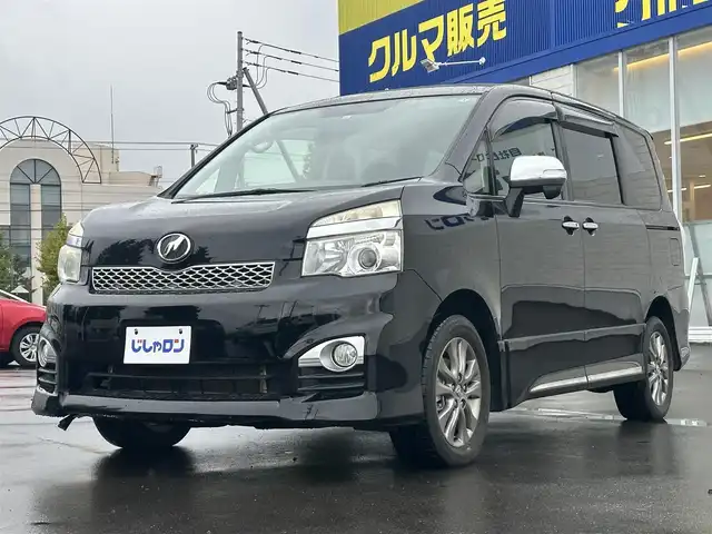 トヨタ ヴォクシー ZS 道北・旭川 2013(平25)年 12.3万km ブラック (株)IDOMが運営する【じしゃロン旭川店】の自社ローン専用車両になります。こちらは現金またはオートローンご利用時の価格です。自社ローンご希望の方は別途その旨お申付け下さい/　/・ベースグレード「ＺＳ」の特別仕様車「ＺＳ煌（きらめき）III」/・純正ナビ(CD/DVD/BT/SD/フルセグ)/・バックカメラ/・ビルトインETC/・ドライブレコーダー/・パドルシフト/・ステリングリモコン/・両側パワースライドドア/・フリップダウンモニター/・電動格納ウィンカーミラー/・プッシュスタート/・スマートキー/・フォグランプ/・取扱説明書
