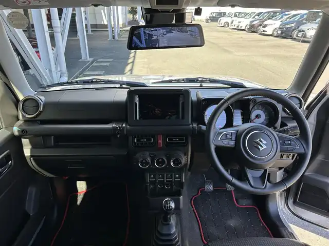 スズキ ジムニー シエラ JC 静岡県 2024(令6)年 0.9万km シルキーシルバーメタリック スズキセーフティサポート/・デュアルセンサーブレーキサポート/・車線逸脱警報機能/・ふらつき警報機能/・先行車発信おしらせ機能/（車両進入禁止/はみ出し禁止/最高速度）/・ハイビームアシスト/社外デジタルインナーミラー/４WD/5速MT/ビルトインETC/クルーズコントロール/シートヒーター/アイドリングストップ/電動格納ミラー（ウィンカーミラー/ミラーヒーター）/純正オプションロッドホルダー/ヘッドラインプウォッシャー/ホワイト照明マルチインフォメーションディスプレイ/革巻きステアリング/プライバシーガラス/ジオランダーG015（人気のホワイトレター）タイヤ