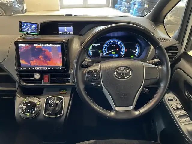 トヨタ ヴォクシー ハイブリッド V 道央・札幌 2015(平27)年 7.5万km ホワイトパールクリスタルシャイン 社外メモリナビ/　・BT/DVD/CD/USB/SD/純正エンジンスターター/両側パワースライドドア/フロントワイパーデアイサー/フリップダウンモニター/バックカメラ/社外GPSレーダー/クルーズコントロール/置くだけ充電/夏タイヤ積込み（純正AW付）/クルーズコントロール