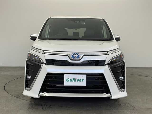 トヨタ ヴォクシー ハイブリッド ZS 煌Ⅲ 兵庫県 2021(令3)年 0.6万km ホワイトパールクリスタルシャイン トヨタセーフティセンス/・プリクラッシュセーフティシステム/・レーンディパーチャーアラート/・オートマチックハイビーム/・先行車発進告知機能/インテリジェントクリアランスソナー/両側パワースライドドア/LEDヘッドライト/・オートライト/トヨタ純正ナビ/・Bluetoothオーディオ/・CD/DVD再生/・SDミュージックサーバー/・フルセグテレビ/・バックカメラ/クルーズコントロール/前後ドライブレコーダー/ウォークスルー/純正フロアマット/ハーフレザーシート/シートヒーター（運転席・助手席）/純正16インチアルミホイール/スマートエントリーシステム/プッシュスタートシステム/ワンオーナー/新車保証書/取扱説明書
