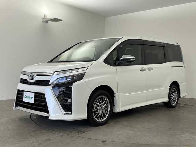 トヨタ ヴォクシー ハイブリッド ZS 煌Ⅲ 兵庫県 2021(令3)年 0.6万km ホワイトパールクリスタルシャイン トヨタセーフティセンス/・プリクラッシュセーフティシステム/・レーンディパーチャーアラート/・オートマチックハイビーム/・先行車発進告知機能/インテリジェントクリアランスソナー/両側パワースライドドア/LEDヘッドライト/・オートライト/トヨタ純正ナビ/・Bluetoothオーディオ/・CD/DVD再生/・SDミュージックサーバー/・フルセグテレビ/・バックカメラ/クルーズコントロール/前後ドライブレコーダー/ウォークスルー/純正フロアマット/ハーフレザーシート/シートヒーター（運転席・助手席）/純正16インチアルミホイール/スマートエントリーシステム/プッシュスタートシステム/ワンオーナー/新車保証書/取扱説明書
