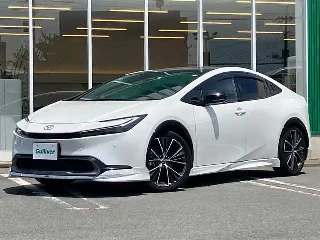 トヨタ プリウス Z 熊本県 2023(令5)年 3.7万km プラチナホワイトパールマイカ エンジンスタートボタン/パワーステアリング/パワーウィンドウ/ワンオーナー/保証書/取扱説明書/１００V充電/パーキングアシスト/アイドリングストップ/スマートキー/スペアキー１本/オートエアコン/クルーズコントロール/USB入力端子/ETC2.0/全方位カメラ/純正12.3インチナビ（BT/フルセグ）/ツインガラスルーフ/電動リアゲート/純正フロアマット/純正アルミホイール/D席パワーシート/D席N席シートヒーター/D席N席エアシート/モデリスタフルエアロ/ABS/横滑り防止装置/コーナーセンサー前後/レーンキープアシスト/オートライト/オートマチックハイビーム/LEDヘッドライト/W＋サイドエアバック/衝突軽減システム/ステアリングヒーター/ワイヤレス充電/BSM/デジタルインナーミラー/トランクトレイ
