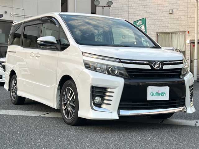 トヨタ ヴォクシー ZS 岡山県 2014(平26)年 13.1万km ホワイトパールクリスタルシャイン 登録時走行距離130407km/フリップダウン後席モニター/純正SDナビ/(AM/FM/BT/TV/DISC)/両側パワースライドドア/ビルトインETC/バックカメラ/MTモード付AT/プッシュスタート/スマートキー/スペアキー/ウォークスルー/純正16インチアルミホイール/パワーウィンドウ/パワーステアリング/記録簿/保証書/取扱説明書