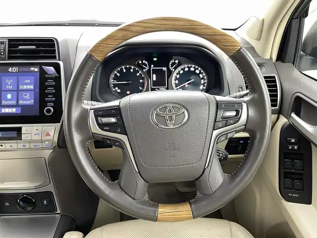 トヨタ ランドクルーザー プラド TX Lパッケージ 熊本県 2023(令5)年 4.5万km ホワイトパールクリスタルシャイン モデリスタエアロ/チルト＆スライド電動ムーンルーフ（挟み込み防止機能付）/ルーフレール/ブラインドスポットモニター［BSM］＋リヤクロストラフィックアラート /9型ワイドディスプレイオーディオ＋T-Connectナビキット/・USB(動画・音声再生/給電）/Bluetooth(ハンズフリー/オーディオ）/Miracast /マルチテレインモニター〈フロント/サイド（左右）＋バックカメラ付〉/====/ベージュ本革シート/前席パワーシート/シートヒーター/シートベンチレーション/衝突被害軽減装置　Toyota Safety Sense/・プリクラッシュセーフティ（歩行者［昼夜］・自転車運転者［昼］検知機能付衝突回避支援タイプ/ミリ波レーダー＋単眼カメラ方式）/・レーンディパーチャーアラート［LDA］（ヨーアシスト機能付）/・オートマチックハイビーム［AHB］/・レーダークルーズコントロール（ブレーキ制御付）/・ロードサインアシスト［RSA］/ミラー型ドライブレコーダー/ビルトインETC2.0/スマートキー /プッシュスタート/LEDヘッドライト/オートライト /オートマチックハイビーム/Fフォグランプ /NITRO Power20インチアルミホイール