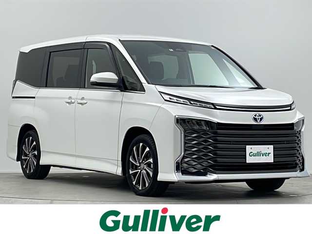 トヨタ ヴォクシー ハイブリッド S－Z 大阪府 2022(令4)年 2.2万km ホワイトパールクリスタルシャイン ワンオーナー/快適利便パッケージ/・ハンズフリーデュアルパワースライドドア/・パワーバックドア/・ナノイーX/・ステアリングヒーター/・D/N/２列目シートヒーター/・オットマン/・角度調整アームレスト/純正10.5インチディスプレイオーディオ(フルセグTV/AM/FM/CD/DVD/USB/HDMI/Miracast)/バックカメラ/ToyotaSafetySense/・プリクラッシュセーフティ/・レーダークルーズコントロール/・オートマチックハイビーム/・ロードサインアシスト/・ドライバー異常時対応システム/・プロアクティブドライビングアシスト/・発進遅れ告知機能　/パーキングサポートブレーキ/オートライト/コーナーセンサー/パワーバックドア/両側パワースライドドア/WAC/オットマン/シートヒーター/ステアリングヒーター/100V電源/純正AW/純正フロアマット