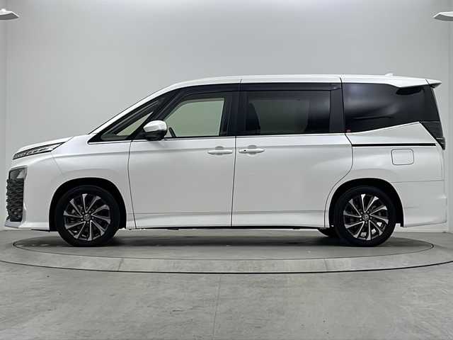 トヨタ ヴォクシー ハイブリッド S－Z 大阪府 2022(令4)年 2.2万km ホワイトパールクリスタルシャイン ワンオーナー/快適利便パッケージ/・ハンズフリーデュアルパワースライドドア/・パワーバックドア/・ナノイーX/・ステアリングヒーター/・D/N/２列目シートヒーター/・オットマン/・角度調整アームレスト/純正10.5インチディスプレイオーディオ(フルセグTV/AM/FM/CD/DVD/USB/HDMI/Miracast)/バックカメラ/ToyotaSafetySense/・プリクラッシュセーフティ/・レーダークルーズコントロール/・オートマチックハイビーム/・ロードサインアシスト/・ドライバー異常時対応システム/・プロアクティブドライビングアシスト/・発進遅れ告知機能　/パーキングサポートブレーキ/オートライト/コーナーセンサー/パワーバックドア/両側パワースライドドア/WAC/オットマン/シートヒーター/ステアリングヒーター/100V電源/純正AW/純正フロアマット