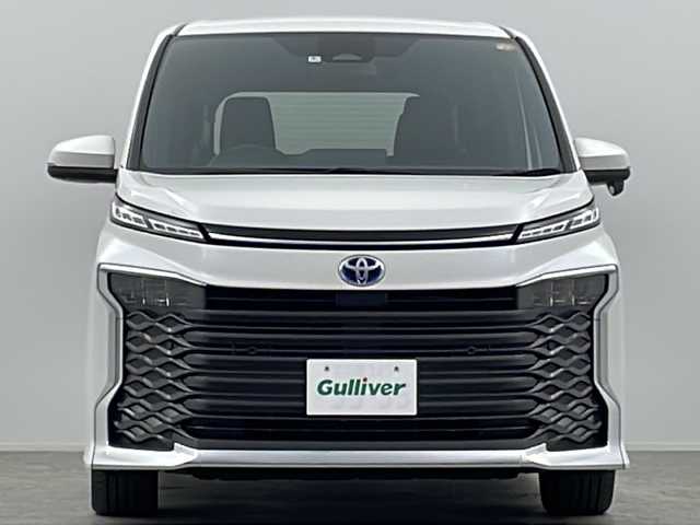 トヨタ ヴォクシー ハイブリッド S－Z 大阪府 2022(令4)年 2.2万km ホワイトパールクリスタルシャイン ワンオーナー/快適利便パッケージ/・ハンズフリーデュアルパワースライドドア/・パワーバックドア/・ナノイーX/・ステアリングヒーター/・D/N/２列目シートヒーター/・オットマン/・角度調整アームレスト/純正10.5インチディスプレイオーディオ(フルセグTV/AM/FM/CD/DVD/USB/HDMI/Miracast)/バックカメラ/ToyotaSafetySense/・プリクラッシュセーフティ/・レーダークルーズコントロール/・オートマチックハイビーム/・ロードサインアシスト/・ドライバー異常時対応システム/・プロアクティブドライビングアシスト/・発進遅れ告知機能　/パーキングサポートブレーキ/オートライト/コーナーセンサー/パワーバックドア/両側パワースライドドア/WAC/オットマン/シートヒーター/ステアリングヒーター/100V電源/純正AW/純正フロアマット