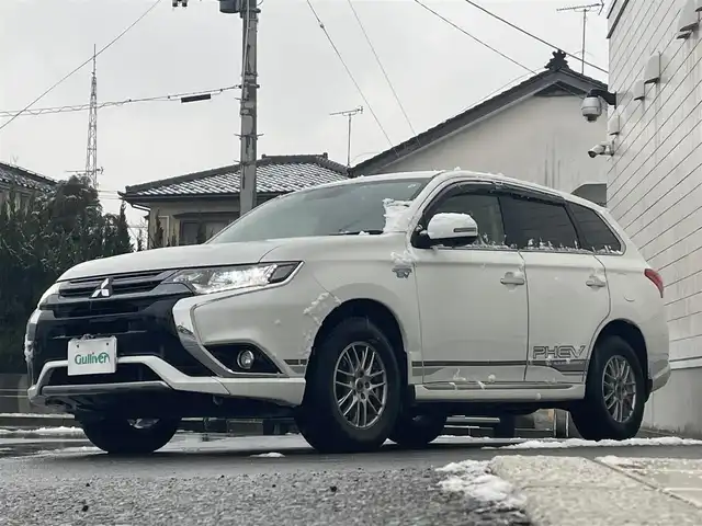 三菱 アウトランダー ＰＨＥＶ G ナビパッケージ 山形県 2015(平27)年 6.6万km シルキーホワイト ４ＷＤ/ハーフレザーシート/純正メモリナビ＆フルセグＴＶ/（ＤＶＤ＆ＢＴ＆ＣＤ＆ＳＤ）/アラウンドビューカメラ/衝突軽減ブレーキ/レーンキープアシスト/ＥＴＣ/社外１６inアルミホイール/オートライト/ＬＥＤライト/フォグランプ/ウィンカーミラー/電動格納ミラー/スマートキー/プッシュスタート/Ｗ＋サイドエアバッグ/横滑り防止装置/ＡＢＳ/ドアバイザー/純正フロアマット/新車保証書/取扱説明書