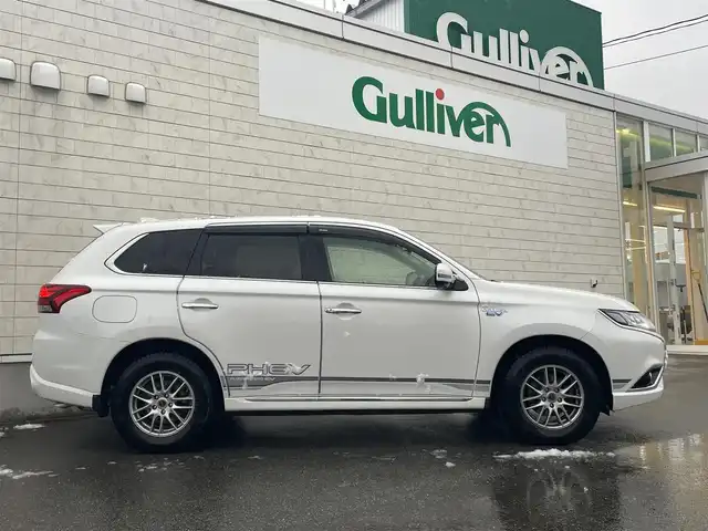 三菱 アウトランダー ＰＨＥＶ G ナビパッケージ 山形県 2015(平27)年 6.6万km シルキーホワイト ４ＷＤ/ハーフレザーシート/純正メモリナビ＆フルセグＴＶ/（ＤＶＤ＆ＢＴ＆ＣＤ＆ＳＤ）/アラウンドビューカメラ/衝突軽減ブレーキ/レーンキープアシスト/ＥＴＣ/社外１６inアルミホイール/オートライト/ＬＥＤライト/フォグランプ/ウィンカーミラー/電動格納ミラー/スマートキー/プッシュスタート/Ｗ＋サイドエアバッグ/横滑り防止装置/ＡＢＳ/ドアバイザー/純正フロアマット/新車保証書/取扱説明書