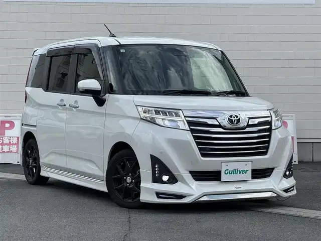 トヨタ ルーミー カスタムG－T 静岡県 2018(平30)年 5.1万km パールホワイトⅢ ●モデリスタフルエアロ/●9インチナビ/(フルセグ/CD/DVD/Bluetooth)/(ALPINE/W9Z)/●バックカメラ/●クルーズコントロール/●衝突被害軽減システム/●レーンキープアシスト/●前後コーナーセンサー/●LEDライト＆フォグランプ/●オートライト/●オートマチックハイビーム/●革巻きステアリング/●ステアリングスイッチ/●ETC/●前方ドライブレコーダー/●両側パワースライドドア/●電動格納ウィンカーミラー/●社外マフラー/●スモークフィルム/●合皮シートカバー/●社外フロアマット/●スマートキー/●プッシュスタート/●ドアバイザー/●社外15インチアルミホイール(STEINER)/●ダブルSRS＋ABS