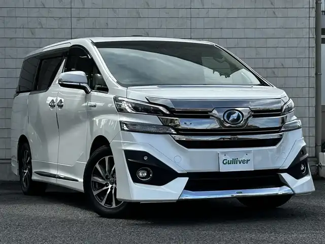 トヨタ ヴェルファイア ハイブリット エグゼクティブ ラウンジ 大分県 2015(平27)年 3.8万km ホワイトパールクリスタルシャイン ワンオーナー/JBLプレミアムサウンド/純正SDナビ/Bluetooth/フルセグ/CD/DVD/モデリスタフルエアロ/Pantneraセキュリティ/全方位カメラ/レーダークルーズコントロール/パワーシート/オットマン/シートメモリー/フリップダウンモニター/100VAC/置くだけ充電（Qi）/社外GPSレーダー/コーナーセンサー/両側パワースライドドア/パワーバックドア/USB・HDMI入力端子/純正アルミホイル17インチ/純正フロアマット/ステアリングスイッチ/ステアリングヒーター/3列シート/オートライト/オートハイビーム/ETC/ドライブレコーダー/チップアップシート/ウッドコンビハンドル/nanoe/スタットレスタイヤ/スペアキー