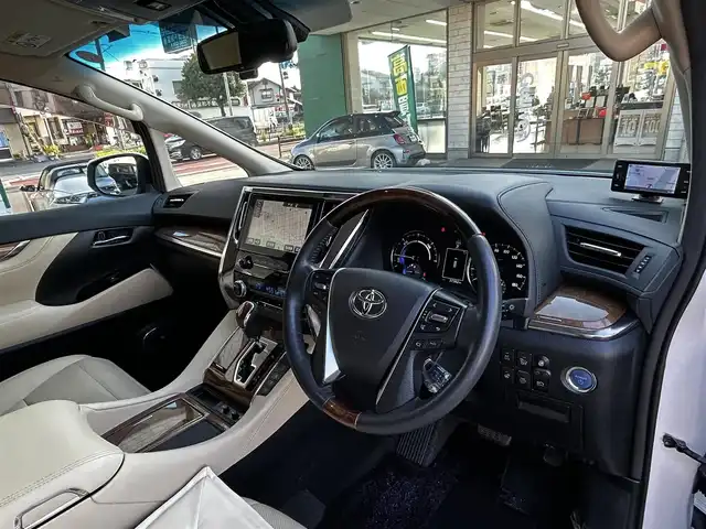 トヨタ ヴェルファイア ハイブリット エグゼクティブ ラウンジ 大分県 2015(平27)年 3.8万km ホワイトパールクリスタルシャイン ワンオーナー/JBLプレミアムサウンド/純正SDナビ/Bluetooth/フルセグ/CD/DVD/モデリスタフルエアロ/Pantneraセキュリティ/全方位カメラ/レーダークルーズコントロール/パワーシート/オットマン/シートメモリー/フリップダウンモニター/100VAC/置くだけ充電（Qi）/社外GPSレーダー/コーナーセンサー/両側パワースライドドア/パワーバックドア/USB・HDMI入力端子/純正アルミホイル17インチ/純正フロアマット/ステアリングスイッチ/ステアリングヒーター/3列シート/オートライト/オートハイビーム/ETC/ドライブレコーダー/チップアップシート/ウッドコンビハンドル/nanoe/スタットレスタイヤ/スペアキー
