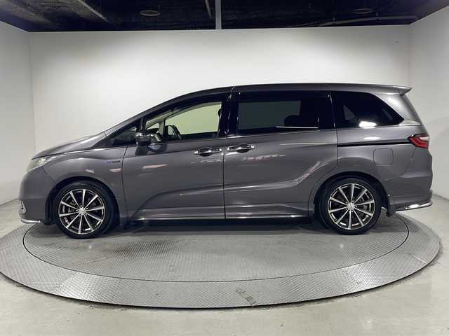 ホンダ オデッセイ ハイブリッド アブソルート・EXホンダセンジング 広島県 2017(平29)年 5.7万km モダンスティールM 禁煙車/純正ナビ/バックカメラ/両側パワースライドドア/ブラインドスポットモニター/1500W給電/レーダークルーズコントロール/ＥＴＣ/オットマン/オートライト/VENERDI18インチアルミホイール(225/45/R18)/衝突被害軽減/レーンキープアシスト/フォグランプ/エアバッグ(運転席/助手席/サイド/カーテン)