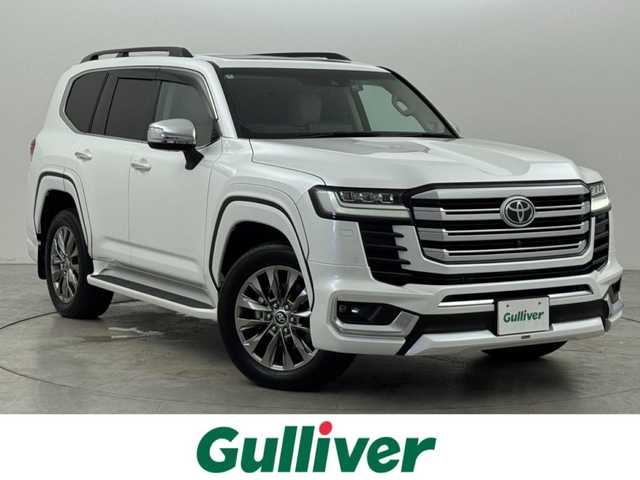 トヨタ ランドクルーザー ZX 福岡県 2023(令5)年 2.2万km プレシャスホワイトパール トヨタメーカー純正12.3インチナビ/【AM/FM/CD/DVD/BT/USB/SD/フルセグ/HDMI】/Apple CarPlay/AndroidAuto/パワーバックドア/パノラミックビューモニター（全方位カメラ）/電動サンルーフ/ビルトインETC2.0/前後ドライブレコーダー【TZ-D215W】/純正11型左右独立リアエンターテインメントシステム/トヨタセーフティセンス/・レーダークルーズコントロール/・プリクラッシュセーフティ/・ロードサインアシスト/・アダプティブハイビームシステム/・ブラインドスポットモニター/・パーキングサポートブレーキ/・リヤクロストラフィックアラート/マルチテレインモニター/おむかえ照明機能付LEDクリアランスランプ/木目調/革巻きコンビステアリング/ステアリングヒーター/ベージュ本革シート/前席パワーシート/前席/2列目ベンチレーション付快適温熱シート/3列目電動格納シート/モデリスタエアロ(F/R/フェンダー)/純正20インチアルミホイール/JBLサウンドシステム/AC100V電源/HUD/クールボックス/電動リヤデフロック/シーケンシャルウィンカー/盗難防止システム/純正トノカバー