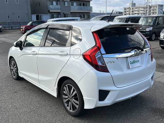 ホンダ フィット ハイブリット Sパッケージ 石川県 2015(平27)年 6.1万km ホワイトオーキッドパール 社外８インチＳＤナビ/フルセグＴＶ/バックカメラ/Ｂｌｕｅｔｏｏｔｈ/ＥＴＣ/プッシュスタート/ＬＥＤライト/オートライト/クルーズコントロール/スペアキー有/純正サイドエアロ/純正アルミホイール/カーテンエアバッグ/リアウィング