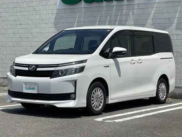 トヨタ ヴォクシー ハイブリッド V 宮崎県 2014(平26)年 7.3万km ホワイトパールクリスタルシャイン 純正ナビ【NSZT-Y64T】/・フルセグTV・Bluetooth・DVD・CD/両側パワースライドドア/クルーズコントロール/ビルトインETC/置くだけ充電/D/N席シートヒーター/LEDヘッドライト/オートライト/フォグライト/純正フロアマット/純正15インチアルミホイール/プッシュスタート/スマートキー・スペアキー有り/取扱説明書・保証書有り