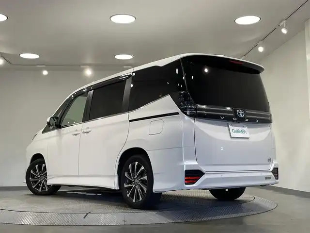 トヨタ ヴォクシー ハイブリッド S－Z 愛知県 2022(令4)年 1.8万km ホワイトパールクリスタルシャイン 純正10.5インチナビ/（Bluetooth/AM/FM/フルセグTV/Carplay/CD/DVD）/快適利便パッケージ/　　-2列目シートヒーター/　　-ステアリングヒーター/　　-オットマン/　　-キャプテンシート/　　-電動バックドア/ベットキット/トヨタセーフティセンス/　　-プリクラッシュセーフティ/　　-レーントレーニングアシスト＋レーンディパーチャーアラート/　　-レーダークルーズコントロール/　　-オートマチックハイビーム/　　-ロードサインアシスト/　　-発進遅れ告知/両側電動スライドドア（ハンズフリー機能有）/ビルトインETC2.0/AC100V/シートヒーター/LEDヘッドライト/LEDフォグランプ/バックカメラ/コーナーセンサー/スマートキー/スペアキー1本/オートブレーキホールド/電動パーキングブレーキ/後席サンシェード