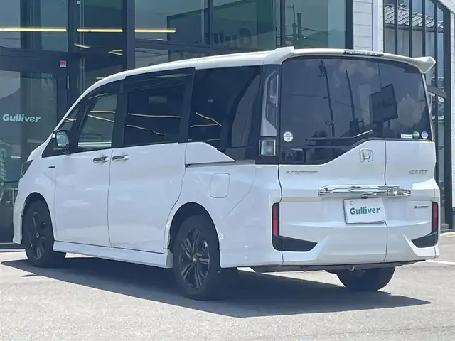 ホンダ ステップワゴン スパーダ ハイブリッド G EX ホンダセンシング 愛媛県 2019(令1)年 6.8万km プラチナホワイトパール 純正9インチナビ（Bluetooth/SD/CD/DVD/AppleCarPlay/AndroidAuto/フルセグTV)/前後ドライブレコーダー/バックカメラ/ビルドインETC/両側パワースライドドア/シートヒーター/ハーフレザーシート/Honda SENSING/・衝突軽減ブレーキ（CMBS）/・誤発進抑制機能/・歩行者事故低減ステアリング/・路外逸脱抑制機能/・渋滞追従機能付アダプティブクルーズコントロール（ACC）/・車線維持支援システム（LKAS）/・先行車発進お知らせ機能/・標識認識機能/・後方誤発進抑制機能/純正16インチアルミホイール/純正フロアマット/ドアバイザー/LEDヘッドライト/フォグランプ/スペアキー1本/スマートキー/取扱説明書/保証書