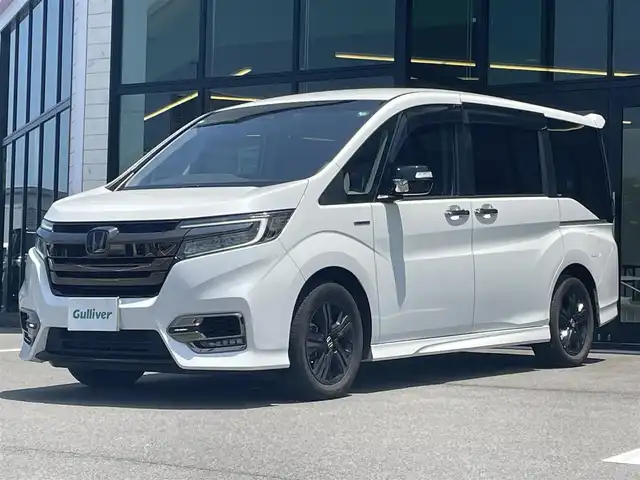 ホンダ ステップワゴン スパーダ ハイブリッド G EX ホンダセンシング 愛媛県 2019(令1)年 6.8万km プラチナホワイトパール 純正9インチナビ（Bluetooth/SD/CD/DVD/AppleCarPlay/AndroidAuto/フルセグTV)/前後ドライブレコーダー/バックカメラ/ビルドインETC/両側パワースライドドア/シートヒーター/ハーフレザーシート/Honda SENSING/・衝突軽減ブレーキ（CMBS）/・誤発進抑制機能/・歩行者事故低減ステアリング/・路外逸脱抑制機能/・渋滞追従機能付アダプティブクルーズコントロール（ACC）/・車線維持支援システム（LKAS）/・先行車発進お知らせ機能/・標識認識機能/・後方誤発進抑制機能/純正16インチアルミホイール/純正フロアマット/ドアバイザー/LEDヘッドライト/フォグランプ/スペアキー1本/スマートキー/取扱説明書/保証書