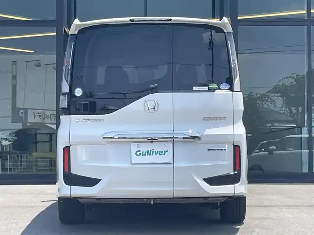 ホンダ ステップワゴン スパーダ ハイブリッド G EX ホンダセンシング 愛媛県 2019(令1)年 6.8万km プラチナホワイトパール 純正9インチナビ（Bluetooth/SD/CD/DVD/AppleCarPlay/AndroidAuto/フルセグTV)/前後ドライブレコーダー/バックカメラ/ビルドインETC/両側パワースライドドア/シートヒーター/ハーフレザーシート/Honda SENSING/・衝突軽減ブレーキ（CMBS）/・誤発進抑制機能/・歩行者事故低減ステアリング/・路外逸脱抑制機能/・渋滞追従機能付アダプティブクルーズコントロール（ACC）/・車線維持支援システム（LKAS）/・先行車発進お知らせ機能/・標識認識機能/・後方誤発進抑制機能/純正16インチアルミホイール/純正フロアマット/ドアバイザー/LEDヘッドライト/フォグランプ/スペアキー1本/スマートキー/取扱説明書/保証書