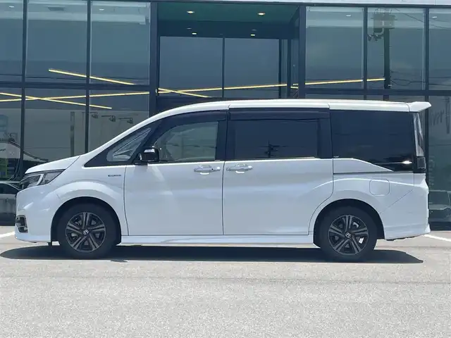 ホンダ ステップワゴン スパーダ ハイブリッド G EX ホンダセンシング 愛媛県 2019(令1)年 6.8万km プラチナホワイトパール 純正9インチナビ（Bluetooth/SD/CD/DVD/AppleCarPlay/AndroidAuto/フルセグTV)/前後ドライブレコーダー/バックカメラ/ビルドインETC/両側パワースライドドア/シートヒーター/ハーフレザーシート/Honda SENSING/・衝突軽減ブレーキ（CMBS）/・誤発進抑制機能/・歩行者事故低減ステアリング/・路外逸脱抑制機能/・渋滞追従機能付アダプティブクルーズコントロール（ACC）/・車線維持支援システム（LKAS）/・先行車発進お知らせ機能/・標識認識機能/・後方誤発進抑制機能/純正16インチアルミホイール/純正フロアマット/ドアバイザー/LEDヘッドライト/フォグランプ/スペアキー1本/スマートキー/取扱説明書/保証書