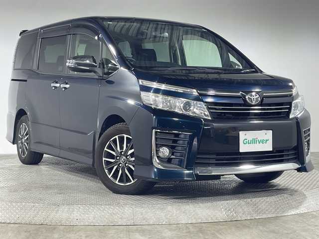 トヨタ ヴォクシー ZS 煌 神奈川県 2015(平27)年 5.7万km ブラッキッシュアゲハガラスフレーク 純正9型ナビ/純正フリップダウン/革巻きステアリング/ECOモード/ウィンカーミラー/横滑り防止装置/純正フロアマット/純正ドアバイザー/純正アルミホイール/両側パワースライドドア/スマートキー/Autoライト/バックカメラ/アイドリングストップ/スペアキー/LEDヘッドライト/電動格納ミラー/フォグランプ/プッシュスタート
