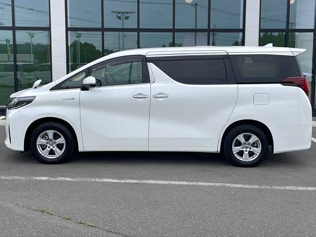 トヨタ アルファードハイブリット X 道東・釧路十勝 2020(令2)年 7.7万km ホワイトパールクリスタルシャイン ・４WD/・純正9インチディスプレイオーディオ/（AM・FM・CD・DVD・USB・BT・フルセグ・Miracast）/・バックカメラ/・純正12.1インチフリップダウンモニター/・両側パワースライドドア/・クルーズコントロール/・社外前後ドライブレコーダー/・白線逸脱防止機能/・オートマチックハイビーム/・オートブレーキホールド/・横滑り防止装置/・セカンドシートオットマン/・革巻きステアリング/・LEDヘッドライト/・LEDフォグライト/・純正フロアマット/・純正ドアバイザー/・ビルトインETC2.0/・純正16インチアルミホイール/・ディーラーオプションスペアタイヤ積み込み/・保証書/・取扱説明書