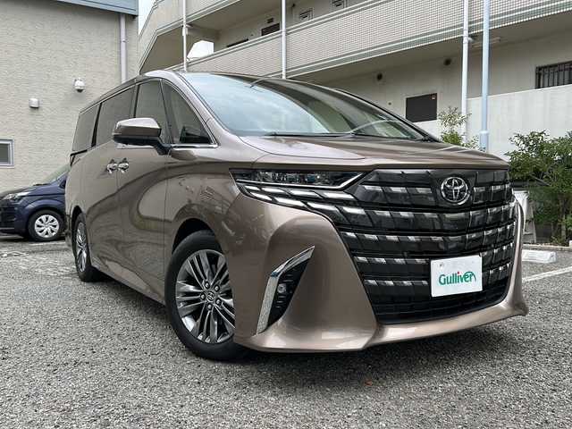 トヨタ アルファード Z 兵庫県 2025(令7)年 0.9万km スティールブロンドM ワンオーナー/14インチディスプレイオーディオプラス/・コネクティッドナビ対応/・フルセグTV・AM/FM・USB入力・HDMI入力/・AppleCarPlay・AndrodiAuto/・ETC2.0/左右独立ムーンルーフ/デジタルインナーミラー/ドライブレコーダー前後/パワーシート（前席）/・マイコンプリセットドライビングポジションシステム/助手席肩口パワーシートスイッチ/2列目エグゼクティブパワーシート/・パワーリクライニング/・大型ヘッドレスト/・快適温熱シート/・充電用USB端子/・パワーオットマン/・折り畳み式サイドテーブル/・大型アームレスト/セーフティセンス（予防安全パッケージ）/・プリクラッシュセーフティ/・レーントレーシングアシスト/・レーンディパーチャーアラート/・全車速追従機能付レーダークルーズコントロール/・アダプティブハイビームシステム/・ロードサインアシスト/トヨタチームメイト/カラーヘッドアップディスプレイ/・タッチトレーサーオペレーション/ユニバーサルステップ/グローブボックス照明/おくだけ充電/床下透過表示機能付パノラミックビューモニター/3眼LEDヘッドライトランプ