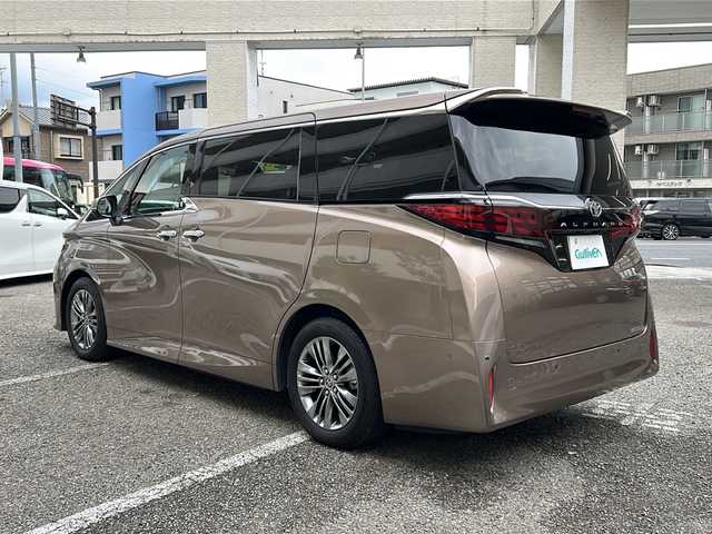 トヨタ アルファード Z 兵庫県 2025(令7)年 0.9万km スティールブロンドM ワンオーナー/14インチディスプレイオーディオプラス/・コネクティッドナビ対応/・フルセグTV・AM/FM・USB入力・HDMI入力/・AppleCarPlay・AndrodiAuto/・ETC2.0/左右独立ムーンルーフ/デジタルインナーミラー/ドライブレコーダー前後/パワーシート（前席）/・マイコンプリセットドライビングポジションシステム/助手席肩口パワーシートスイッチ/2列目エグゼクティブパワーシート/・パワーリクライニング/・大型ヘッドレスト/・快適温熱シート/・充電用USB端子/・パワーオットマン/・折り畳み式サイドテーブル/・大型アームレスト/セーフティセンス（予防安全パッケージ）/・プリクラッシュセーフティ/・レーントレーシングアシスト/・レーンディパーチャーアラート/・全車速追従機能付レーダークルーズコントロール/・アダプティブハイビームシステム/・ロードサインアシスト/トヨタチームメイト/カラーヘッドアップディスプレイ/・タッチトレーサーオペレーション/ユニバーサルステップ/グローブボックス照明/おくだけ充電/床下透過表示機能付パノラミックビューモニター/3眼LEDヘッドライトランプ
