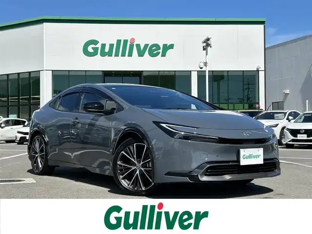 トヨタ プリウス Z 愛媛県 2023(令5)年 4.3万km グレー 禁煙車/登録時走行距離：42731km/純正12.3インチディスプレイオーディオ/フルセグTV/充電用USBタイプC/ワイヤレス充電器/ワンオーナー/ドライブレコーダー/レーダークルーズコントロール/プリクラッシュセーフティ/フロントクロストラフィックアラート/レーントレーシングアシスト/ロードサインアシスト/ドライバー異常時対応システム/プロアクティブドライビングアシスト/緊急時操舵支援/レーンチェンジアシスト/レーンディバーチャアラート/オートマチックハイビーム/ブラインドスポットモニター/パーキングサポートブレーキ/LEDヘッドランプ/LEDライン発光/LEDアクセサリーランプ/ビルトインETC2.0/ドライブレコーダー/合皮巻きステアリングホイール/オートエアコン/スマートエントリー/スタートシステム/パワーバックドア/アクセサリーコンセント/寒冷地仕様ウィンドウシールデアイサー/スペアタイヤ/パノラマルーフ/デジタルインナーミラー/床下通過表示機能