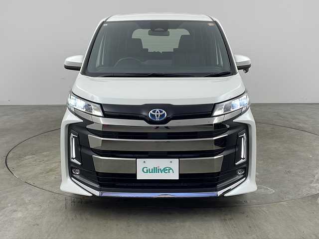 トヨタ ノア ハイブリッド S－Z 兵庫県 2023(令5)年 5.8万km ホワイトパールクリスタルシャイン ・純正10.5インチディスプレイナビオーディオ/・Bluetooth/CD/DVD/USB/フルセグテレビ/・バックカメラ/・トヨタセーフティセンス/・プリクラッシュセーフティ/・レーントレーシングアシスト/・レーダクルーズコントロール/・オートマチックハイビーム/・ロードサインアシスト/・ドライバー異常時対応システム/・プロアクティブドライビングアシスト/・発進遅れ告知機能/・ブラインドスポットモニター/・パーキングサポートブレーキ/・車両接近通報装置/・前後クリアランスソナー/・純正フリップダウンモニター/・電子パーキングブレーキ/・オートブレーキホールド/・両側パワースライドドア/・ステアリングスイッチ/・合皮＋ファブリックシート/・前席シートヒーター/・純正フロアマット/・LEDヘッドライト/・モデリスタシグネチャーイルミブレード/・モデリスタサイドスカート/・ビルトインETC2.0/・100V充電