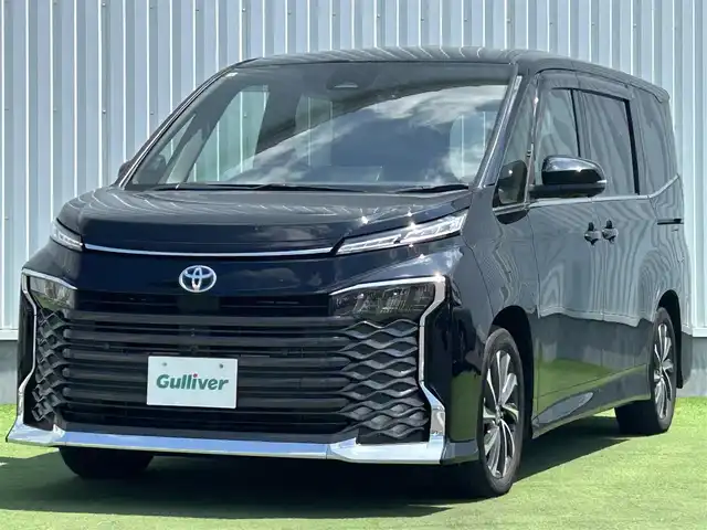 トヨタ ヴォクシー ハイブリッド S－Z 香川県 2022(令4)年 3万km アティチュードブラックマイカ 登録時走行距離：30074km/メーカー純正ナビ/　CD DVD BT フルセグTV/全方位カメラ/両側パワースライドドア/プリクラッシュセーフティシステム/レーンキープアシスト/レーダークルーズコントロール/クリアランスソナー/オートハイビーム/LEDヘッドライト/オートライト/パーキングアシスト/ビルトインETC2.0/前後ドライブレコーダー/AC100V充電/電子パーキングブレーキ/ハーフレザーシート/シートヒーター/革巻きステアリング/ステアリングスイッチ/プッシュスタート/スマートキー