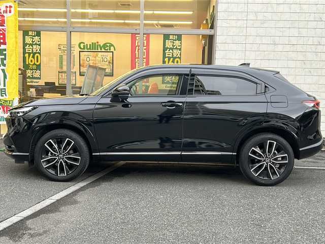 ホンダ ヴェゼル ハイブリッド e:HEV Z 埼玉県 2023(令5)年 2.3万km クリスタルブラックパール 登録時22818km/ワンオーナー/純正ナビ/フルセグ/BT/USB/アラウンドビューモニター/ビルトインETC2.0/前後ドライブレコーダー/衝突被害軽減ブレーキ/路外逸脱抑制機能/踏み間違い衝突軽減システム/ヒルディセントコントロール/レーダークルーズコントロール/パドルシフト/ハーフレザーシート/前席シートヒーター/革巻きハンドル/ステアリングリモコン/ステアリングヒーター/パワーバックドア/パーキングセンサーシステム/プッシュスタート/置くだけ充電/電動格納ミラー/ウィンカーミラー/オートライト/横滑り防止装置/純正フロアマット/純正18インチアルミホイール/LEDヘッドライト/フォグランプ/リアスポイラー/ドアバイザー/スマートキー×2/保証書/取説