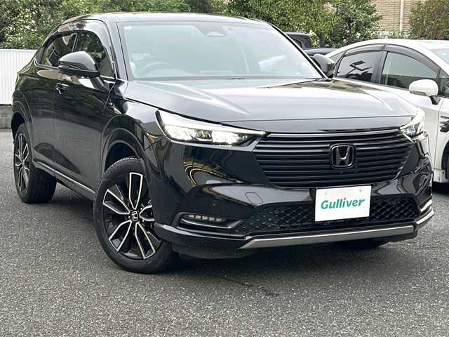 ホンダ ヴェゼル ハイブリッド e:HEV Z 埼玉県 2023(令5)年 2.3万km クリスタルブラックパール 登録時22818km/ワンオーナー/純正ナビ/フルセグ/BT/USB/アラウンドビューモニター/ビルトインETC2.0/前後ドライブレコーダー/衝突被害軽減ブレーキ/路外逸脱抑制機能/踏み間違い衝突軽減システム/ヒルディセントコントロール/レーダークルーズコントロール/パドルシフト/ハーフレザーシート/前席シートヒーター/革巻きハンドル/ステアリングリモコン/ステアリングヒーター/パワーバックドア/パーキングセンサーシステム/プッシュスタート/置くだけ充電/電動格納ミラー/ウィンカーミラー/オートライト/横滑り防止装置/純正フロアマット/純正18インチアルミホイール/LEDヘッドライト/フォグランプ/リアスポイラー/ドアバイザー/スマートキー×2/保証書/取説