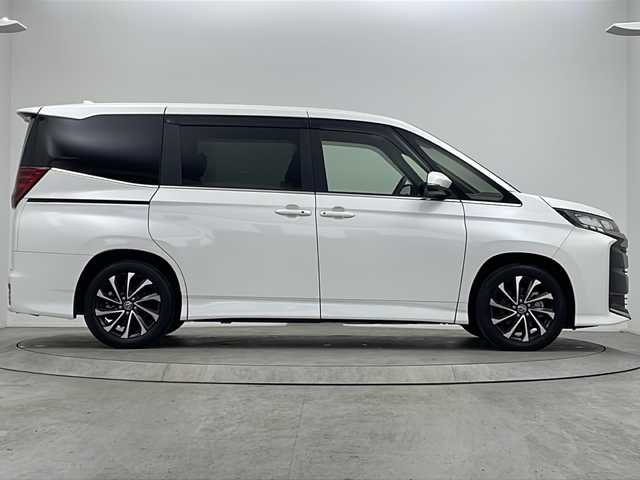 トヨタ ノア ハイブリッド S－Z 大阪府 2023(令5)年 0.5万km ホワイトパールクリスタルシャイン 純正10.5インチディスプレイオーディオ/【ナビ/BT/フルセグTV/USB/DVD/HDMI]/快適利便パッケージ/・ハンズフリーデュアルパワースライドドア/・パワーバックドア/・ナノイー X/・ステアリングヒーター/・シートヒーター/・オットマン/バックカメラ/ETC2.0/両側パワースライドドア/衝突被害軽減システム/クルーズコントロール追従/コーナーセンサー前後/オートライト/ライトレベライザー/ハーフレザーシート/純正17インチAW/純正フロアマット