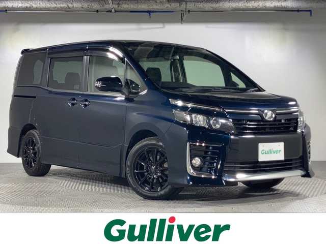 トヨタ ヴォクシー ZS 沖縄県 2015(平27)年 8.7万km ブラッキッシュアゲハガラスフレーク 禁煙車/社外ナビ/Bluetooth/フルセグTV/AM/FM/パワースライドドア/8人乗り/アイドリングストップ/ステアリングリモコン/マニュアルモード付オートマ/スマートキー/プッシュスタート/前席オートパワーウィンドウ/ＥＴＣ/サンシェード