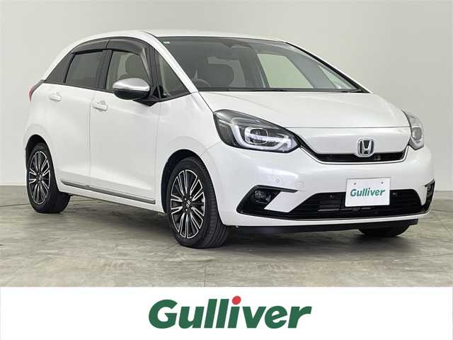 ホンダ フィット e:HEVリュクス 千葉県 2022(令4)年 2.1万km プラチナホワイトパール 禁煙車/ホンダセンシング/・誤発進抑制機能（前方・後方）/・近距離衝突軽減ブレーキ（前方・後方）/・路外逸脱抑制機能/・歩行者事故低減ステアリング/・車線維持支援システム/・渋滞追従機能付きアダプティブクルーズコントロール/・先行車発進お知らせ機能/・標識認識機能/・オートハイビーム/純正9インチナビ/・型式：VXU-225FTi/・CD/DVD/フルセグTV/Bluetooth/バックカメラ/シートヒーター/ステアリングヒーター/ワイヤレス充電/コーナーセンサー/ビルトインＥＴＣ/キルティングパーフォレーション本革シート/本革巻ステアリングホイール/LEDオートライト/LEDフォグランプ/LUXE専用エクステリア（プラチナ調クロームメッキ・フロントバンパーモールディング）/LUXE専用エクステリア（プラチナ調クロームメッキ・ドアロアーガーニッシュ）/LUXE専用エクステリア（プラチナ調クロームメッキ・テールゲートロアーガーニッシュ）/LUXE専用デザイン16インチアルミホイール/純正フロアマット/電動パーキング/オートブレーキホールド/スペアキー1本